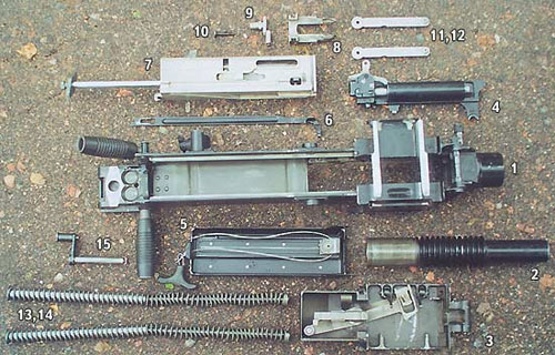 Детали частичной разборки гранатомёта АГС-17 «Пламя»: 1 - короб (лоток не снят), 2 - ствол, 3 - приёмник, 4 - УСМ, 5 - механизм перезарядки, 6 - спусковая планка, 7 - затвор, 8 - досылатель, 9 - боевая плита, 10 - ударник, 11, 12 - рычаги затвора, 13, 14 - возвратные пружины, 15 - ось затыльника