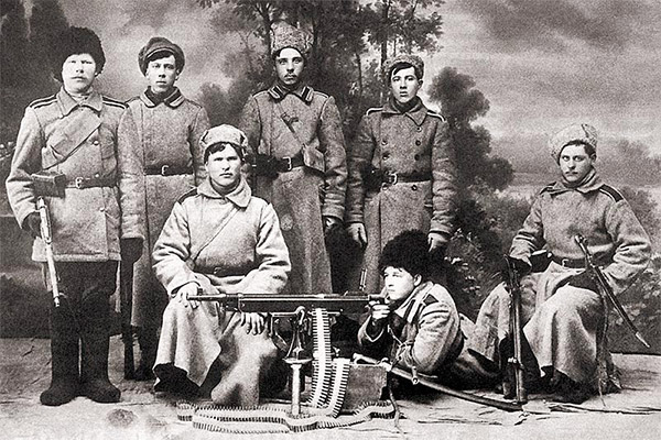 Студийное фото времен Гражданской войны в России: солдаты армии А. Колчака позируют на фоне пулемета «Кольт». 1919 г.