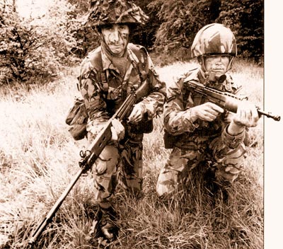 Старая винтовка L1A1 калибра 7,62x51 мм (слева) и новая SA80 калибра 4,85 мм, представленные вместе на рекламном армейском фотоснимке в 1976 г. Хотя и широкоугольный объектив искажает размеры L1A1, очевидно, что схема «буллпап» компактнее и удобнее в обращении