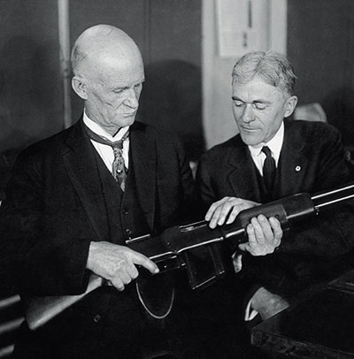 Джон Мозес Браунинг (слева) с автоматической винтовкой М1918 собственной конструкции в руках.