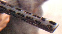 Скошенный передний срез кожуха ствола и три фигурных отверстия в нём выолняют роль дульного тормоза компенсатора (по типу ППШ)