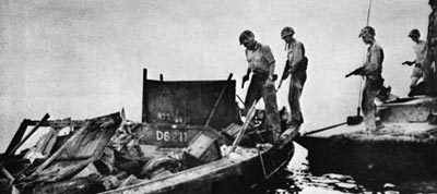 Американские солдаты с пистолетами Кольт М 1911А1 осматривают японскую трофейную лодку. 1944 год