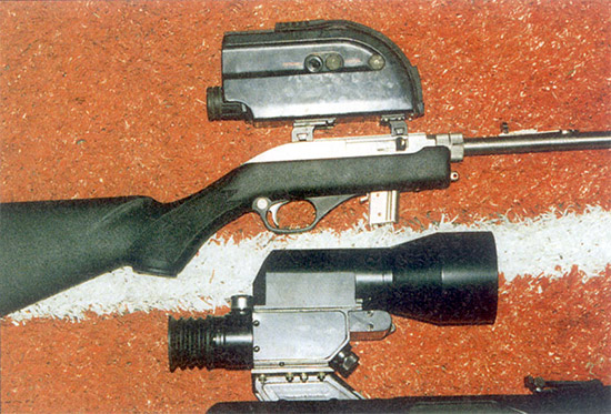 Модернизированный прицел ПОНД-4, установленный на снайперской винтовке СВД (внизу), и ночной прицел ПОН-3 для охотников, установленный на самозарядной малокалиберной винтовке «Marlin». В затемненном тире из-за отвратительной регулировки пристрелять ПОН-3 так и не удалось, следовательно, не удалось оценить и его возможности, хотя картинка выглядела достаточно ясной и четкой. Заслуживает внимания модификация ПОНД-4, на которой устранены недостатки, выявленные на «Выстреле». Наконец-то сошлись прицельные марки дневного и ночного каналов, и вводить поправку при переключении не нужно. Кронштейн стал заметно жестче, что позволило установить прицел на СВД. Все электрические цепи выключателей сведены на один четырехпозиционный (его ручка видна на передней поверхности корпуса прицела), что повысило удобство эксплуатации. Однако ПОНД-4 не стал доступнее для армейских снайперов.